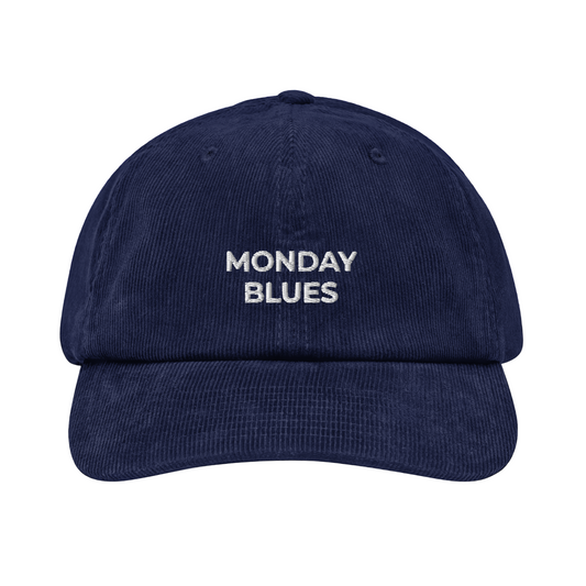 Navy blue cap with 'MONDAY BLUES' text on a white background