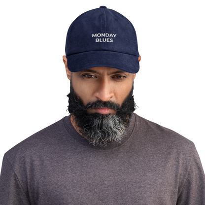 Man wearing a navy cap with 'MONDAY BLUES' text on a white background